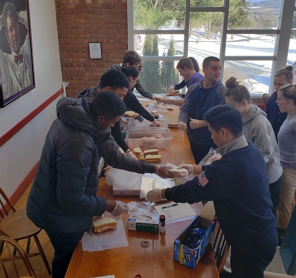 Students gathered in the dining hall assembling meals to donate to the hungry